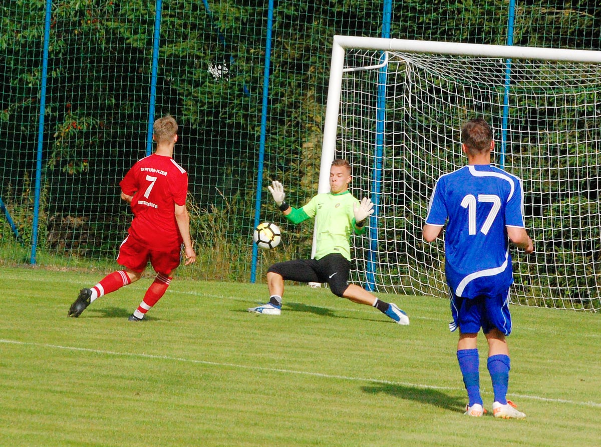 Výborný výkon podal v tachovské brance Petr Landrgott, na snímku likviduje šanci Velfla. Image